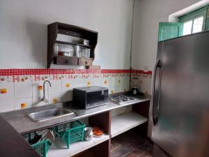 cocina con fregadero y nevera de acero inoxidable en MAMBE HOSTEL en Bogotá