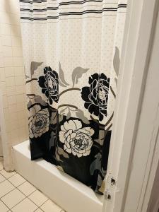 a shower curtain with flowers on it in a bathroom at Muna’s Place in Newark
