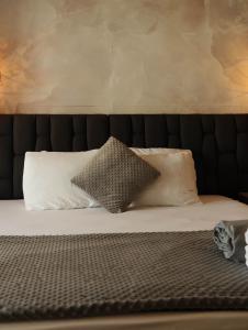 a bed with a black headboard with two pillows at Bahia 79 Apartasuites Cerca al Centro in Cartagena de Indias