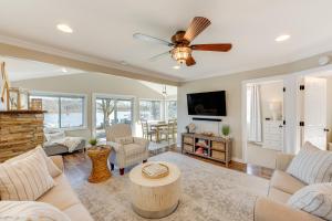 a living room with a couch and a ceiling fan at Lakefront Highland Home with Dock about 2 Mi to Milford! 