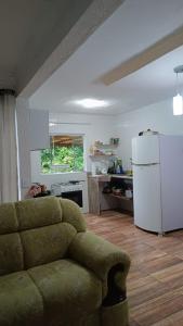 - un salon avec un canapé et un réfrigérateur blanc dans l'établissement Casa de Praia, à Angra dos Reis