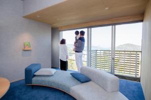 two people looking out the window of a living room at Senpokaku in Toba