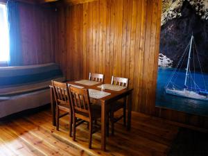a dining room with a table and chairs and a boat at House with a view of the lake, for 6 people in Łazy