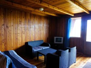 a living room with a chair and a table at House with a view of the lake, for 6 people in Łazy