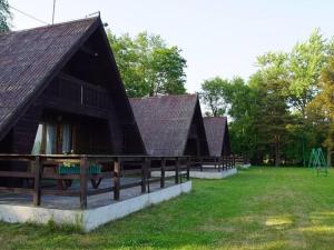 a large building with a fence and a playground at House with a view of the lake, for 6 people in Łazy