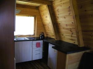 a kitchen in a log cabin with a sink and a window at Summer house for 4 people, close to the sea in Łazy