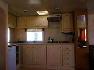 a kitchen with white cabinets and a sink and a window at Dutch houses for 6 people, close to the sea, azy in Łazy