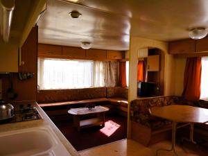 a kitchen and living room of an rv at Dutch houses for 6 people, close to the sea, azy in Łazy