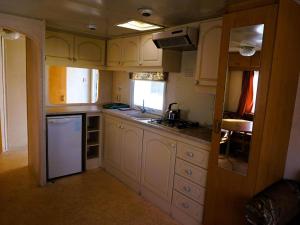 a small kitchen with white cabinets and a sink at Dutch houses for 6 people, close to the sea, azy in Łazy