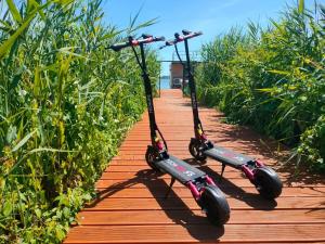 two scooters are parked on a wooden path at Dutch houses for 6 people, close to the sea, azy in Łazy
