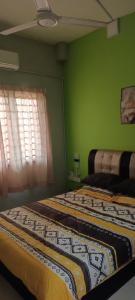 2 łóżka w pokoju z zielonymi ścianami w obiekcie HOMESTAY D'TEPIAN CASA, BANDAR SERI IMPIAN KLUANG w mieście Kluang