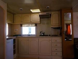 a kitchen with white cabinets and a sink and a window at Dutch House near Lake Jamno and Beach in Łazy +6 photos