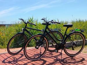 two bikes parked next to each other on a sidewalk at Dutch houses for 4 people, close to the sea in Łazy