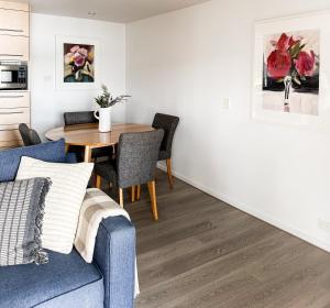 a living room with a blue couch and a table at Shack on the Bay - A Lovely Bayside Cabin in Strahan