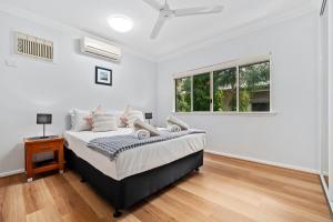 a white bedroom with a bed and a window at Oliva St 2 Bedroom Palm Cove Apartment in Palm Cove +12 photos
