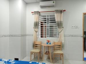 - une table et des chaises dans une chambre avec fenêtre dans l'établissement 18 Homestay Star's, à Cần Thơ