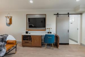 1 dormitorio con escritorio, espejo y TV en Hotel Avanti en Santa Maria