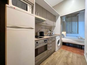 cocina con nevera blanca, lavadora y secadora en Stay U-nique Apartments Boters en Barcelona