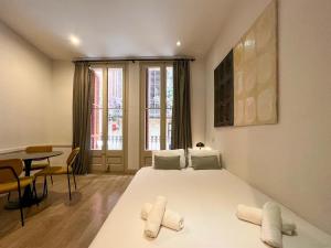 バルセロナにあるStay U-nique Apartments Botersのベッドルーム(大きな白いベッド1台、テーブル付)