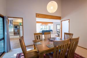 a dining room with a wooden table and chairs at Ridge Retreat in Rotorua