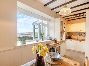 a kitchen with a table and a large window at Little Gidding in Frosterley