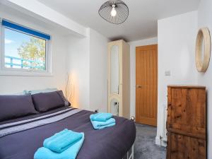 sypialnia z łóżkiem z niebieskimi ręcznikami w obiekcie Hayfield w mieście Paignton