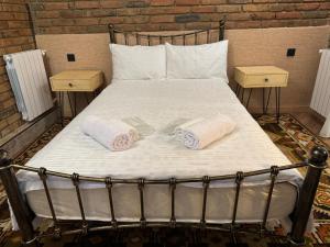 a bed with two towels on it with two night stands at Сity center Loft style Apartment in Tbilisi City