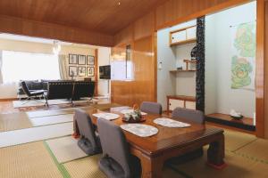 uma sala de estar com uma mesa de madeira e cadeiras em Kamenoko House - Vacation STAY 15285 em Kadena