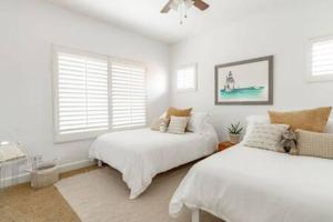 um quarto branco com 2 camas e uma janela em Carlsbad Dream House with Hot Tub Walk to Beach em Carlsbad
