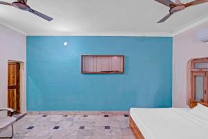 a bedroom with a blue wall and a bed at OYO Dream Square in Gwalior