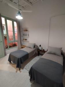 1 dormitorio con 2 camas y ventana grande en CasaLins en Chascomús