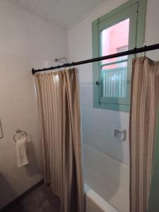 baño con cortina de ducha y ventana en CasaLins en Chascomús
