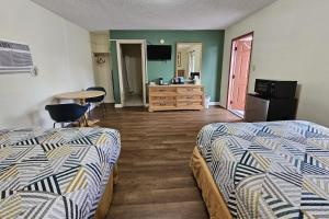 ein Hotelzimmer mit 2 Betten und einem Tisch in der Unterkunft Rodeway Inn Fort Pierce US Highway 1 in Fort Pierce