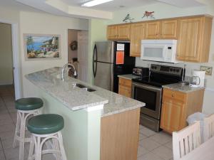 a kitchen with a counter and two stools at Golf Resort Villa 2607 with Outdoor Pool in Calabash +42 photos