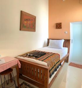 a small bedroom with a bed and a desk at The Cabin Hotel Ambasador in Yogyakarta