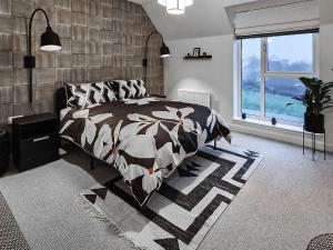 Un dormitorio con una cama en blanco y negro y una ventana en Miller Time en Croy