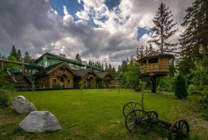 a large log house with a yard with some rocks at Apartman 25 Vysoké Tatry in Štrba