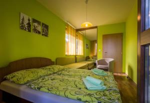 a bedroom with green walls and a bed with blue pillows at Apartman 25 Vysoké Tatry in Štrba