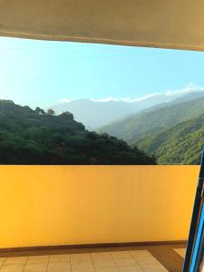 ventana con vistas a la montaña en Las orquideas en Caraballeda