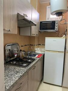 uma cozinha com um fogão e um frigorífico branco em Appartement à RABAT AGDAL em Rabat