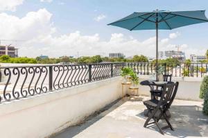 een tafel en stoel met een parasol op een balkon bij Downtown 1-BR with Balcony - 5 Minutes to Wynwood in Miami
