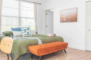 een slaapkamer met een bed met een oranje bank bij Downtown 1-BR with Balcony - 5 Minutes to Wynwood in Miami