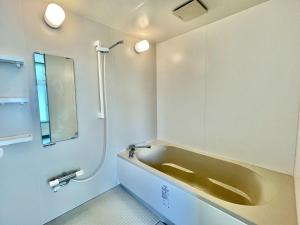 a bathroom with a bath tub and a sink at LivingAnywhere Commonsうるま 4bed room - Vacation STAY 65070v in Uruma