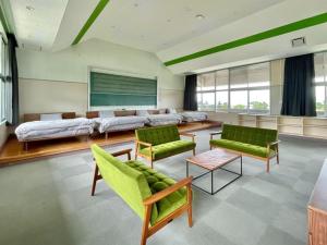 sala de estar con sillas verdes y sofá en LivingAnywhere Commonsうるま 4bed room - Vacation STAY 65070v, en Uruma