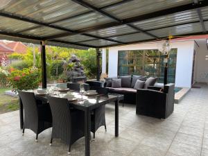 a patio with a table and chairs and a couch at Bali Residence in Mae Pim