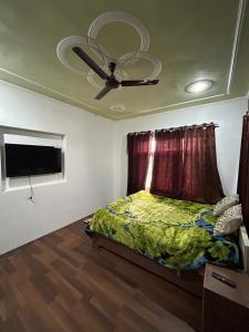 1 dormitorio con 1 cama y ventilador de techo en Home sleeper en Srinagar