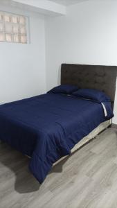een bed met een blauw dekbed in een slaapkamer bij Estancia entre las nubes in Chachapoyas