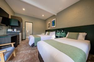 a hotel room with two beds and a television at Everton Park Hotel in Brisbane