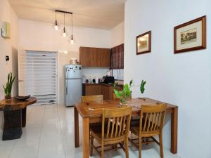 a kitchen and dining room with a wooden table and chairs at Ipoh - Apartment Casa Klebang 1 Fully Air-Con Suite in Chemor