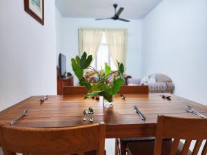 a wooden table with a plant on top of it at Ipoh - Apartment Casa Klebang 1 Fully Air-Con Suite in Chemor